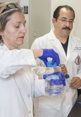 Luis Cuello, PhD, in lab with assistant cover image for story front lines of battle