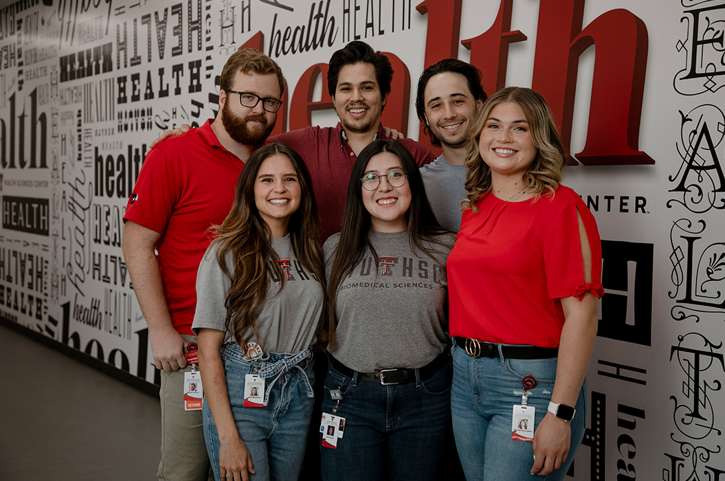 six biomedical students standing infront of the health decorative wall