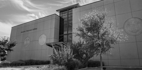 A modern, concrete university building on a sunny day.
