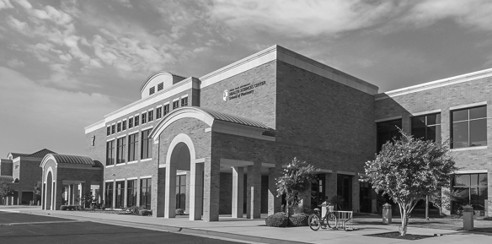 A multi-story brick university building with arches.
