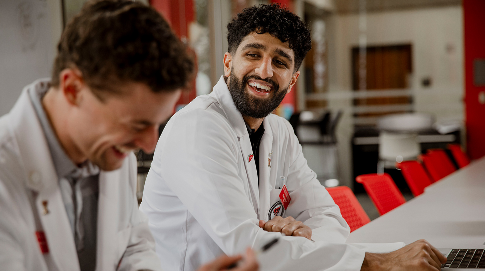 medicine students sitting smiling at each other in a classroom