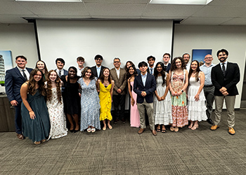 A group of TTUHSC Premedical Enrichment students standing in a room smiling at a banquet