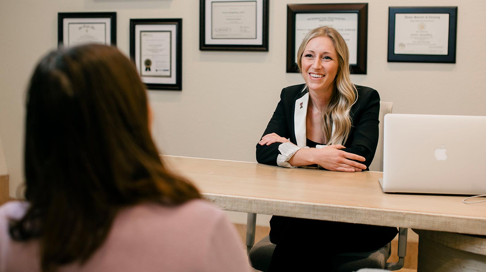 Jessica Spiegelberg sitting in her office with a patient smiling