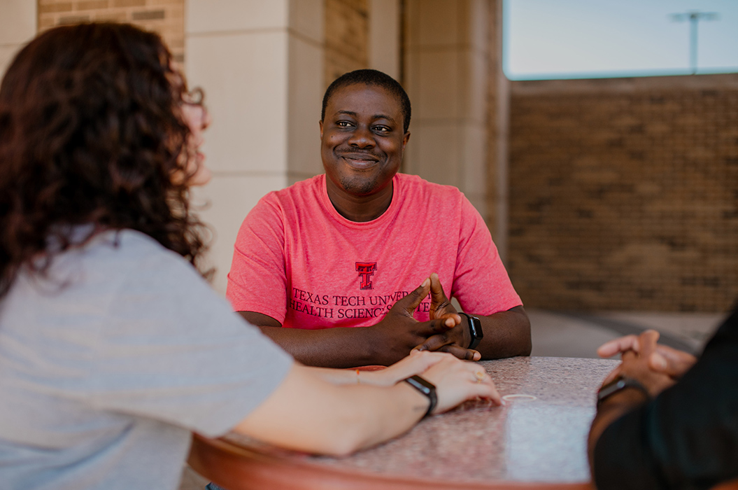 public health students sitting at a table on the Abilene campus smiling at each other