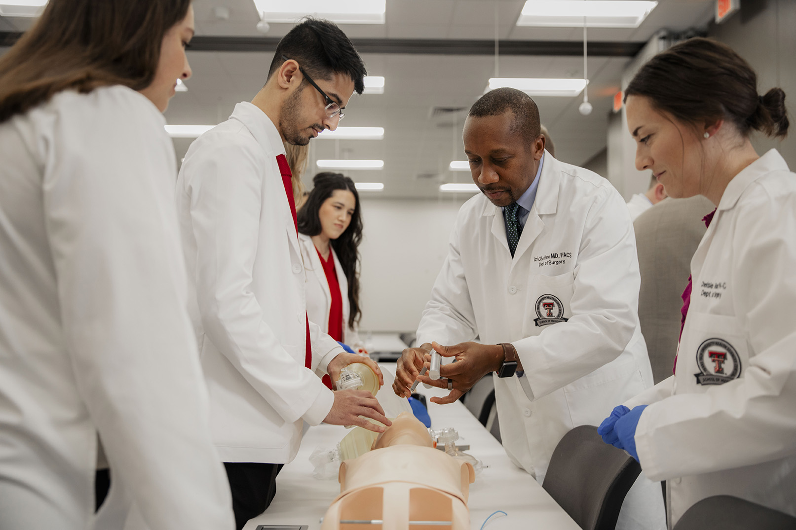 Group of students watch Dr. Obokhare demonstrate test